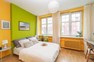 a green bedroom with a bed and a window at Mariacki View Apartment in Gdańsk