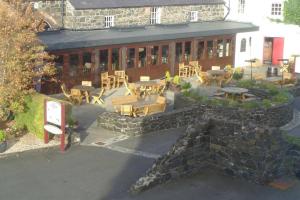 a patio with tables and chairs in front of a building at Mews Apartment, Bushmills in Bushmills