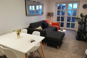 een woonkamer met een bank en een tafel bij Mews Apartment, Bushmills in Bushmills