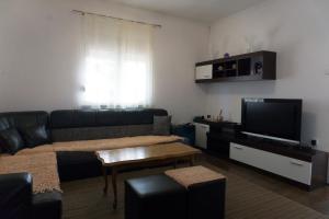 a living room with a couch and a flat screen tv at Vila za odmor Svitavac in Trebinje
