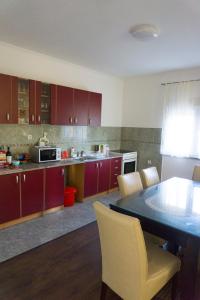 a kitchen with red cabinets and a table and chairs at Vila za odmor Svitavac in Trebinje