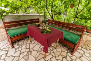 a table and two benches with a table and fruit at Apartman Rene in Crikvenica +7 photos
