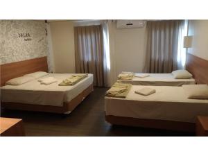 2 camas en una habitación de hotel con 2 camas en Hotel Rio de Pedras, en Itabirito