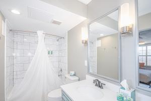 a bathroom with a shower, sink, and toilet at Seven Hills Suites in Tallahassee