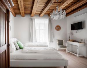 1 dormitorio con cama, escritorio y lámpara de araña en Florand Rooms&Wine en Sopron