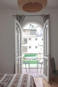 a bedroom with a door open to a patio with a table at Hotel De Blasis in Santiago