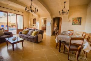 a living room with a table and a couch at Villa Mandolina in Għarb