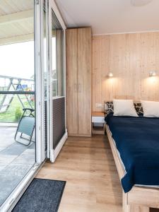 sypialnia z łóżkiem i balkonem w obiekcie Nasze Wybrzeże w Sarbinowie