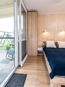 een slaapkamer met een bed en een balkon bij Nasze Wybrzeże in Sarbinowo