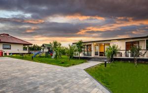 une maison avec une aire de jeux dans la cour dans l'établissement Nasze Wybrzeże, à Sarbinowo