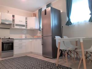 uma cozinha com um frigorífico de aço inoxidável e uma mesa em Nelli Apartman em Keszthely