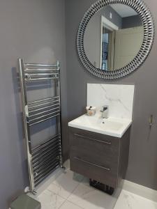 ein Bad mit einem Waschbecken und einem Spiegel in der Unterkunft Ayala in Portstewart
