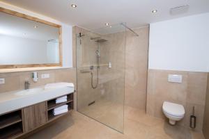 a bathroom with a shower and a sink and a toilet at Alpenvilla Berchtesgaden Appartements in Berchtesgaden