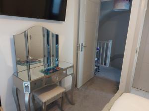 a dressing table with a mirror and a chair in a room at Ayala in Portstewart