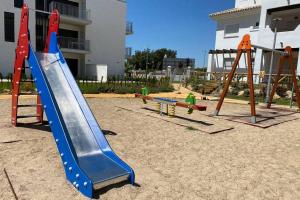 un parque infantil con tobogán y columpios en Apartamento junto a la playa en Punta Candor, en Rota