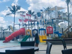 Una ragazza in piedi di fronte a un parco acquatico di Salinas Exclusive Resort Apartamento 2 quartos a Salinópolis