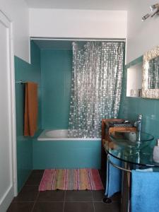 y baño con lavabo de cristal y bañera. en Upstairs Home, en Ponta Delgada