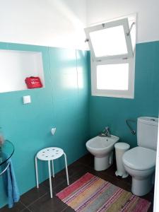 a green bathroom with a toilet and a sink at Upstairs Home in Ponta Delgada +19 photos