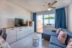 モロ・デル・ハブレにあるResidence Palm Garden Ocean Viewのリビングルーム(青いソファ、薄型テレビ付)