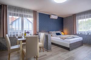 sypialnia z łóżkiem i stołem oraz jadalnia w obiekcie MyFlat Premium Resort w Siófoku