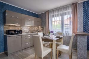 kuchnia z drewnianym stołem i krzesłami oraz jadalnia w obiekcie MyFlat Premium Resort w Siófoku