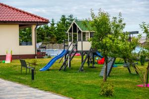 une aire de jeux avec un toboggan dans une cour dans l'établissement Nasze Wybrzeże, à Sarbinowo
