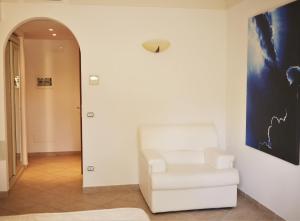 a white chair in a hallway with a painting on the wall at Hotel Villa Ceselle in Anacapri