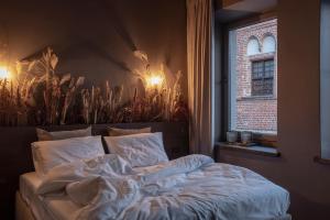 un letto in una camera da letto con finestra di Bōheme House a Kaunas
