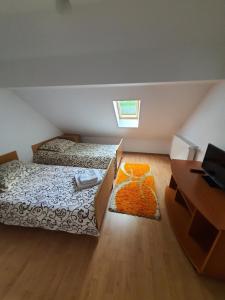 een kleine slaapkamer met 2 bedden en een bureau bij Casa Alma in Borşa