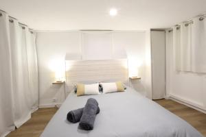 - une chambre avec un grand lit blanc et 2 serviettes dans l'établissement T2 avec terrasse / 10mn grande plage, à Royan