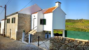 a white house with a pool in front of it at Casa das Lajes - Alojamento Local in Vila Nova de Foz Coa