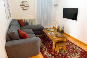 ein Wohnzimmer mit einem Sofa und einem Tisch in der Unterkunft ΔΗΜΗΤΣΑΝΑΣ ΤΟΠΟΣ Νύμφη Θεισόα in Dimitsana