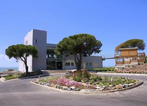 un bâtiment avec un jardin au milieu d'une route dans l'établissement Mazagonia, à Mazagón