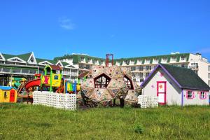 a playground in a field with a building in the background at Therma ECO - Private Beach & Free Parking in Kranevo