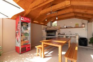 a kitchen with a coke refrigerator and a wooden table at Apartmani Olivia in Bibinje