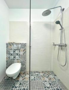 a bathroom with a toilet and a glass shower at Apartament Jurata 30 in Jurata