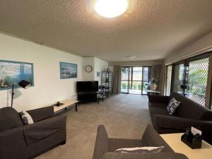 ein großes Wohnzimmer mit Sofas und einem TV in der Unterkunft Bay Parklands, 56 2 Gowrie Ave - ground floor, air conditioned, wifi & Foxtel in Nelson Bay