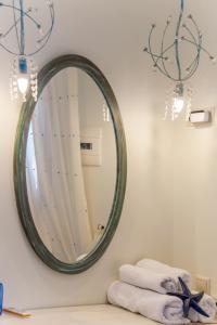 Villa Nostalgia Lentas No1 في لينتاس: حمام مع مرآة كبيرة على الحائط