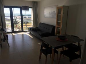 - un salon avec un canapé et une table avec des chaises dans l'établissement Hermoso departamento con vista al mar, à Mar del Plata