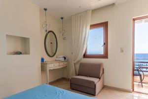 1 dormitorio con silla, espejo y ventana en Villa Nostalgia Lentas No1 en Léntas
