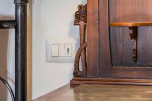 a light switch on a wall next to a table at Casale Le Brecce in Otricoli +28 photos