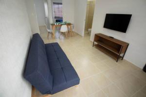 普拉亞德爾卡曼的住宿－Apartamento Escoto en PDC，客厅配有蓝色的沙发和电视
