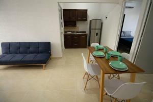 普拉亞德爾卡曼的住宿－Apartamento Escoto en PDC，客厅配有桌子和蓝色沙发