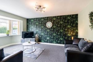 a living room with a couch and a tv at BEAUTIFUL Contractor and Family House - M18 & A1 - Private Parking & Big Garden in Doncaster