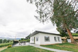 a white house with a table and a tree at Hummingbird Estate in Central Point