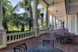 a porch with tables and chairs and palm trees at Grand Sandestin at Sandestin Resort by Tufan in Destin
