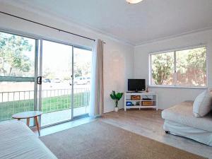 a living room with a couch and a large window at Ocean Views in Huskisson