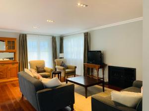 sala de estar con 2 sofás y TV en Kauri Cottage - Russell Cottage Collection, en Russell