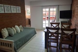 1 dormitorio con 1 cama, 2 sillas y TV en Departamentos EL Colono PB 3 en Viedma