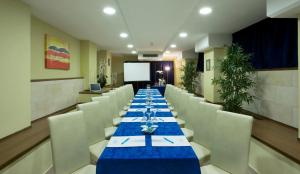 a long dining room with a long table and white chairs at Hotel Du Soleil in Rimini